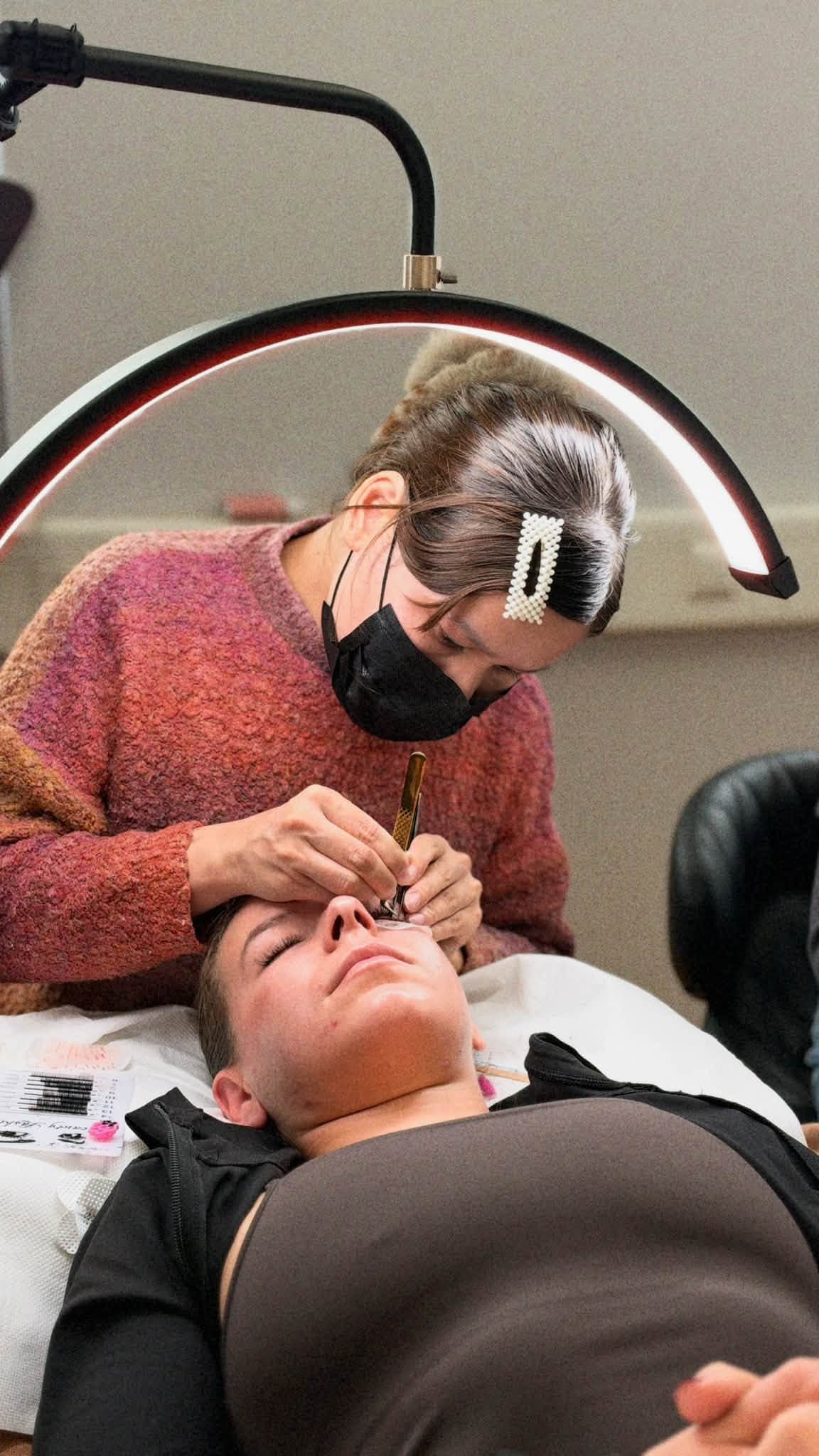 Schülerin bei der praktischen Wimpernverlängerung am Modell